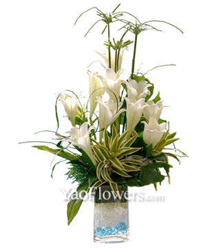 White Lilies With Song Of India In Clear Glass Filled With Blue Pebbles 