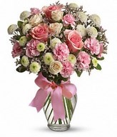 Pretty pink roses, spray roses and miniature carnations, white button spray chrysanthemums, lavender limonium and green pittosporum