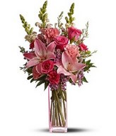 mix of fresh pink flowers such as roses, Asiatic lilies, carnations, snapdragons and waxflower. 