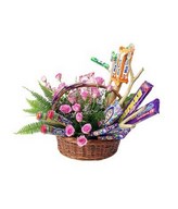 Assorted cadies and pink roses arrangement in a basket