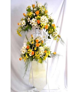 Standing flower arrangement of orange roses and daisies