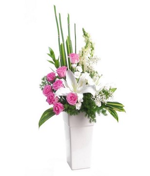 Arrangement of pink rose, white lily, white carnation and white snap dragon in vase