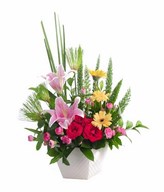 Arrangement of pink lily and carnation, red rose and yellow gerbera with filler in vase