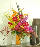 Bird Of Paradise, Pink Gerberas With mixed colour of Orchids In Glass Vase Filled With Orange