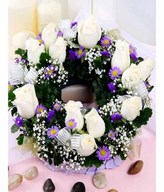 White Roses With Baby Breath, Purple Flower and leaves in a wreath centrepiece arrangement