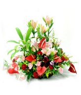 Basket of colorful lilies, carnations, and anthuriums.