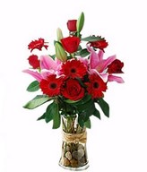 Scarlet gerberas and pink lilies in a hand bouquet